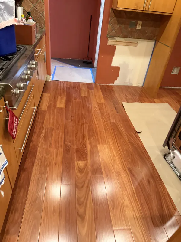 Glossy cherry hardwood through a kitchen with deep red walls