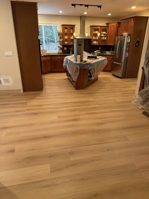 Oak boards running past a kitchen island towards the window