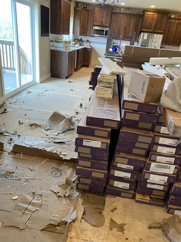 Stacks of new flooring waiting on a subfloor stripped back to the boards