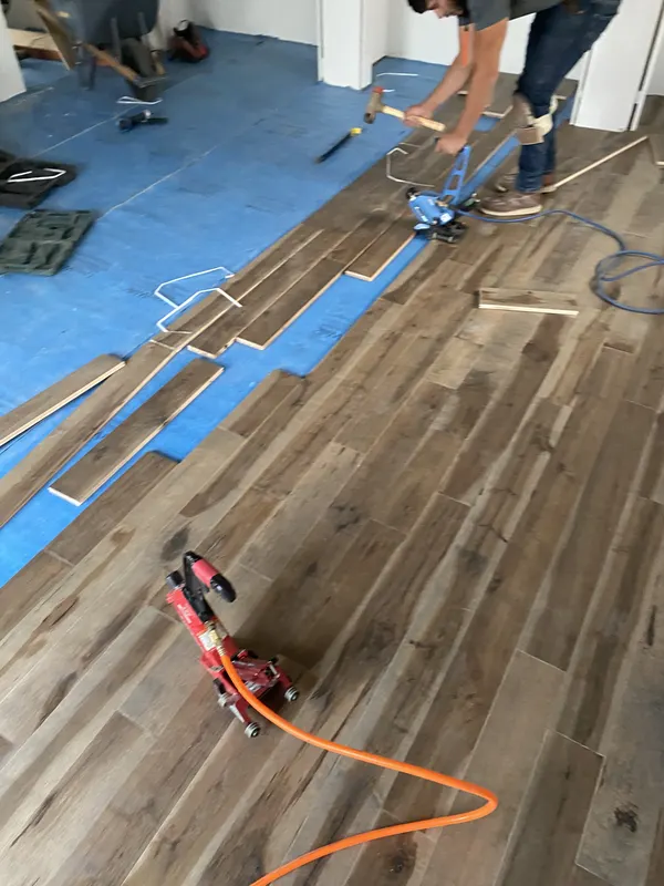 Underlayment down and the first boards going in over a prepared subfloor