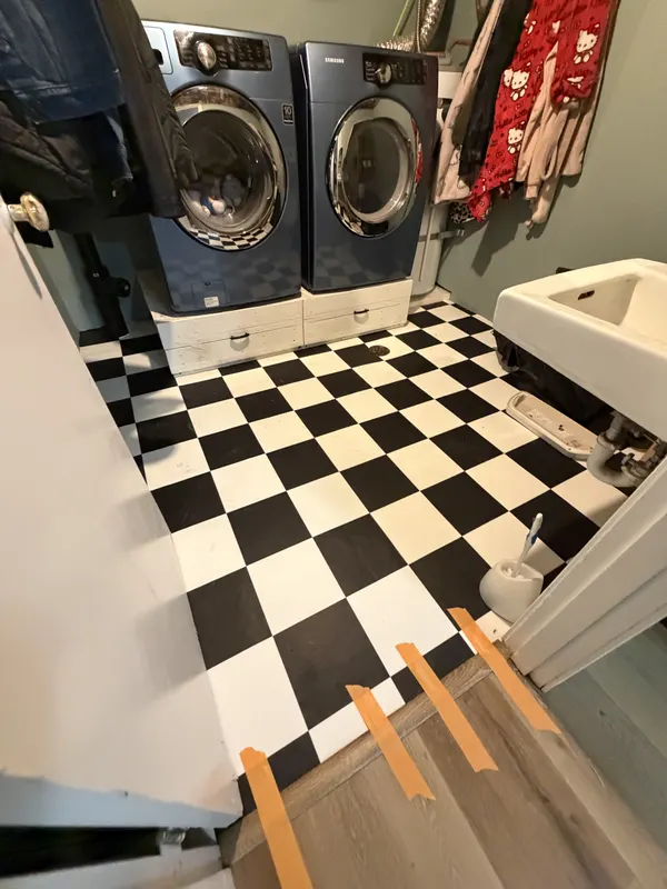 Black and white checkerboard vinyl tile in a utility room
