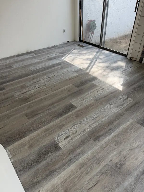 Laminate planks laid up to a sliding door in a bright room