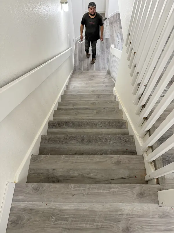 Grey plank treads on an open staircase with a white balustrade