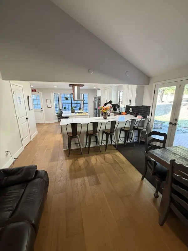 Warm oak boards running under a dining table towards tall windows