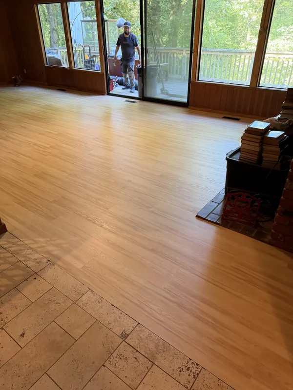 Light oak floor running through a wood panelled living room towards the garden