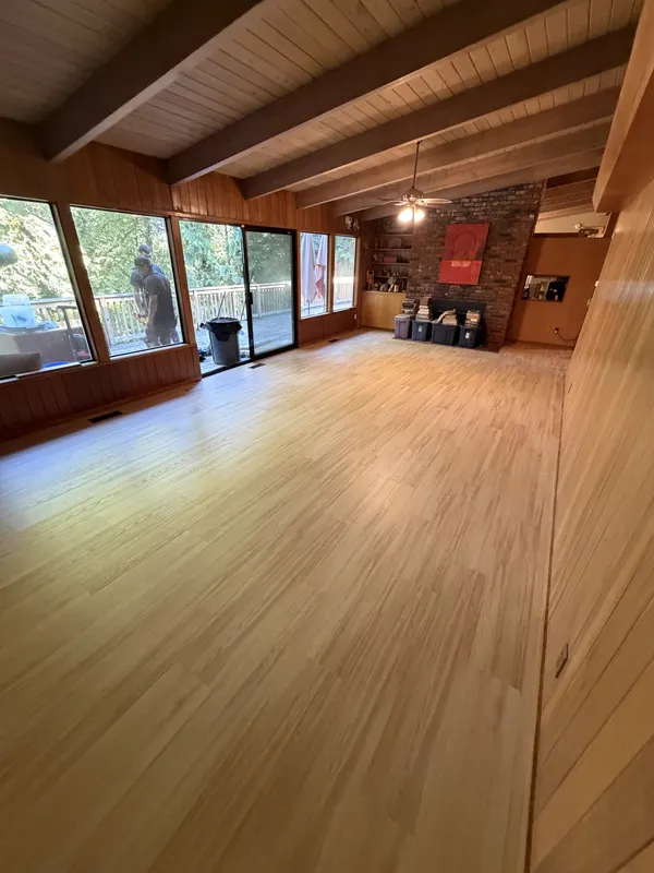 Light oak floor in a wood panelled room with exposed beams