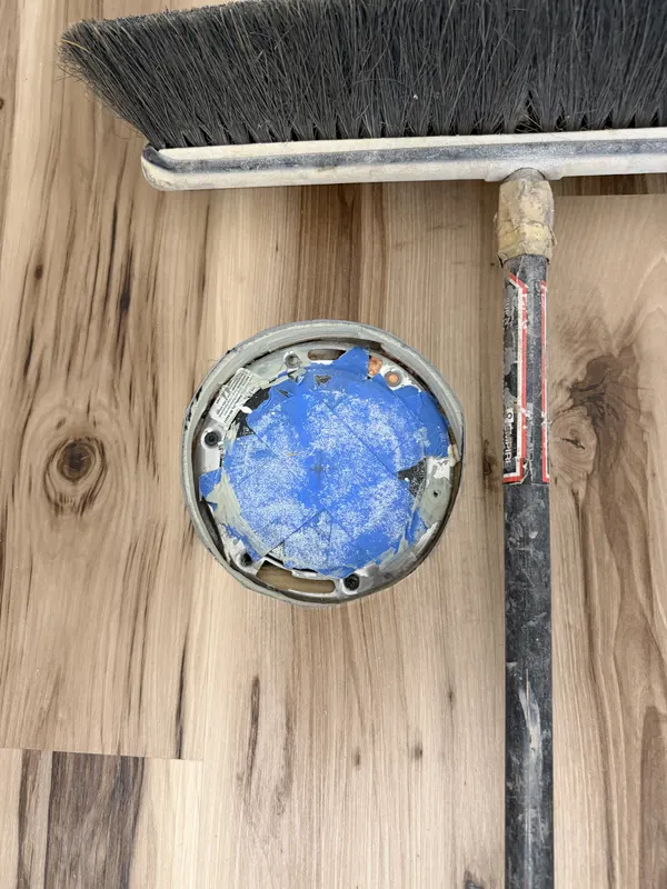 A broom and hand tools resting on freshly laid plank during a clean down