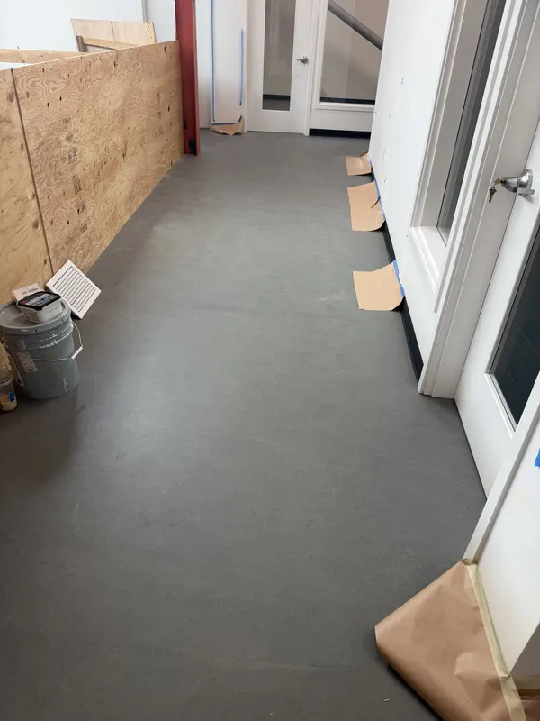 Grey sheet flooring run through a commercial space still being built out