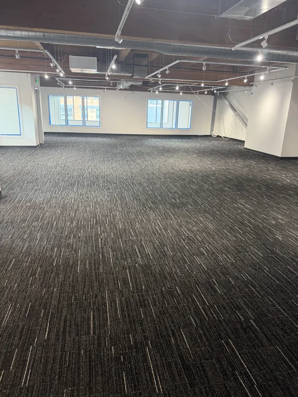 Carpet run out under an exposed ceiling in an open commercial space