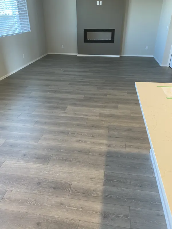 Wide grey vinyl plank running through an empty new build living room