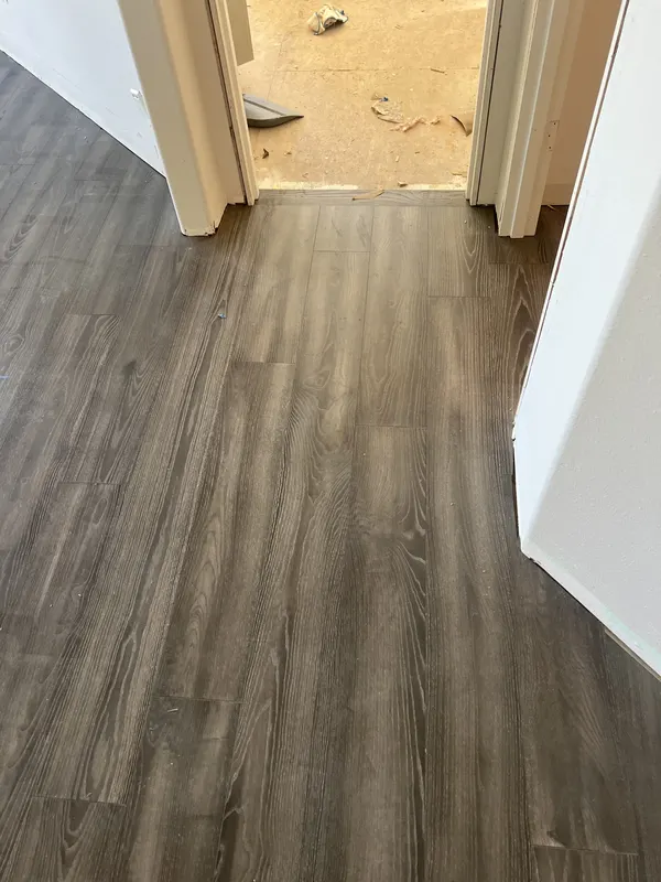 Grey toned luxury vinyl plank running through an open living room